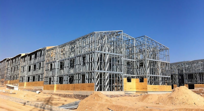 Metal framework of a building under construction, clear sky.