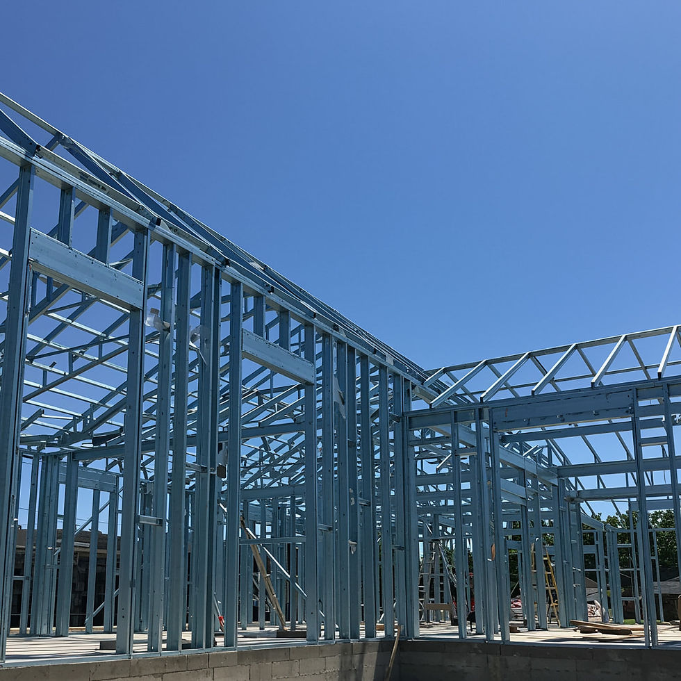 An under-construction building featuring exposed framework and construction equipment on the site.