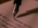 A fountain pen writing illegible letters on lined paper.