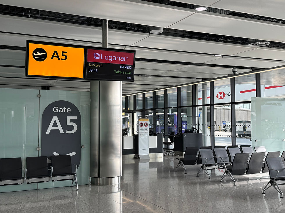 Empty airport Gate A5 with Loganair sign for Kirkwall 09:45, rows of black seats, bright modern terminal, no passengers.