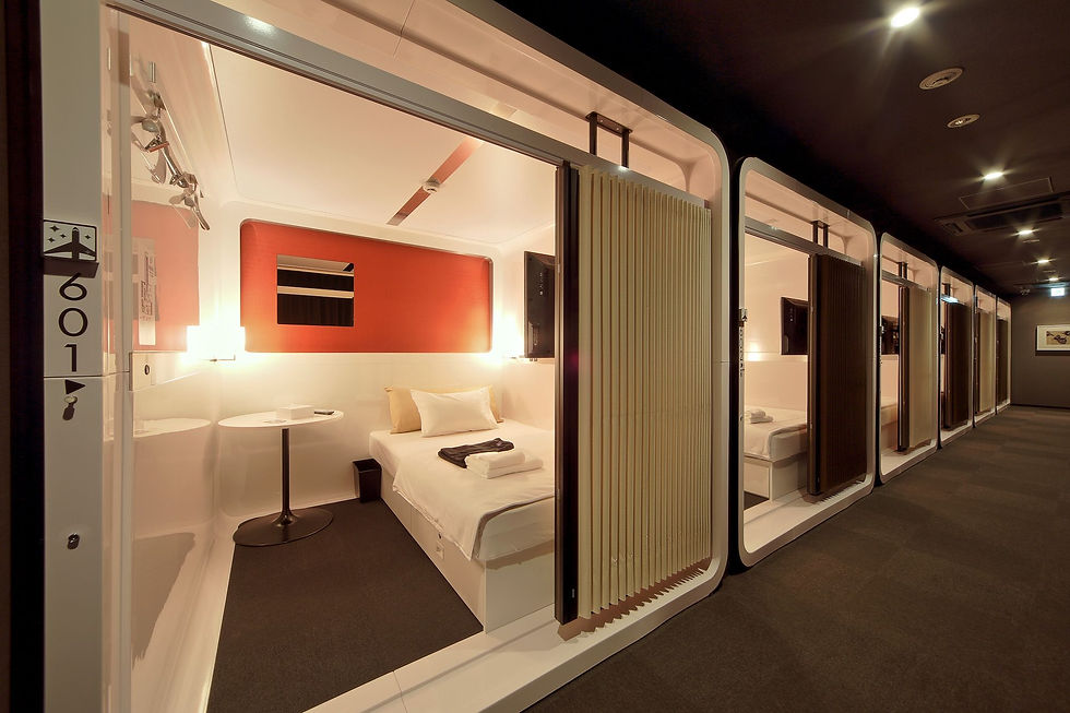 Modern capsule hotel hallway with open pod showing a neatly made bed, small table, and warm lighting. Room number 601 visible.