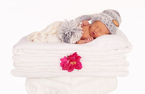 Neugeborenes Baby bei professionellem Fotoshooting.
