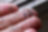 Fingers covered in small, colorful fragments of micro plastic held against a blurred background, highlighting pollution concerns.