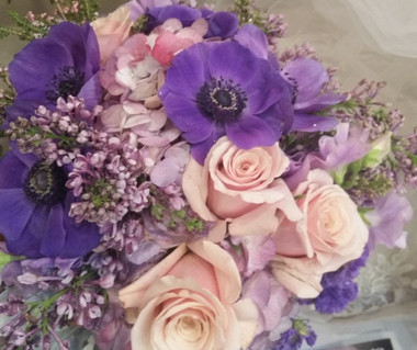 bridal bouquet of deep purple anemone pair up with lavender roses and lavender wax flower 