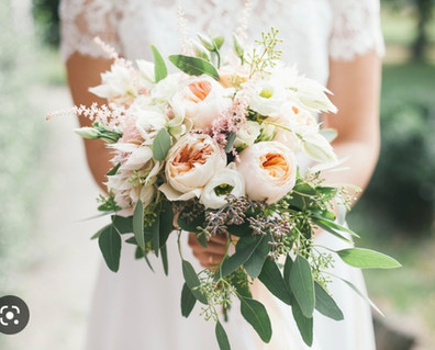 bride hold bouquet of pale peach and white peony and ranunculus