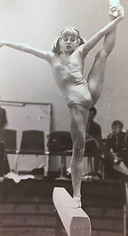 Old photograph of a gymnast girl standing on one foot on a beam