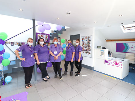 Female carers in purple uniforms, standing in the 4Life Healthcare reception area