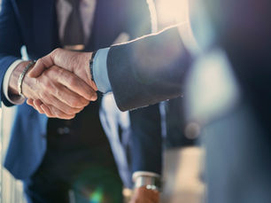 Aperto de mãos entre executivos, simbolizando parceria entre empresas