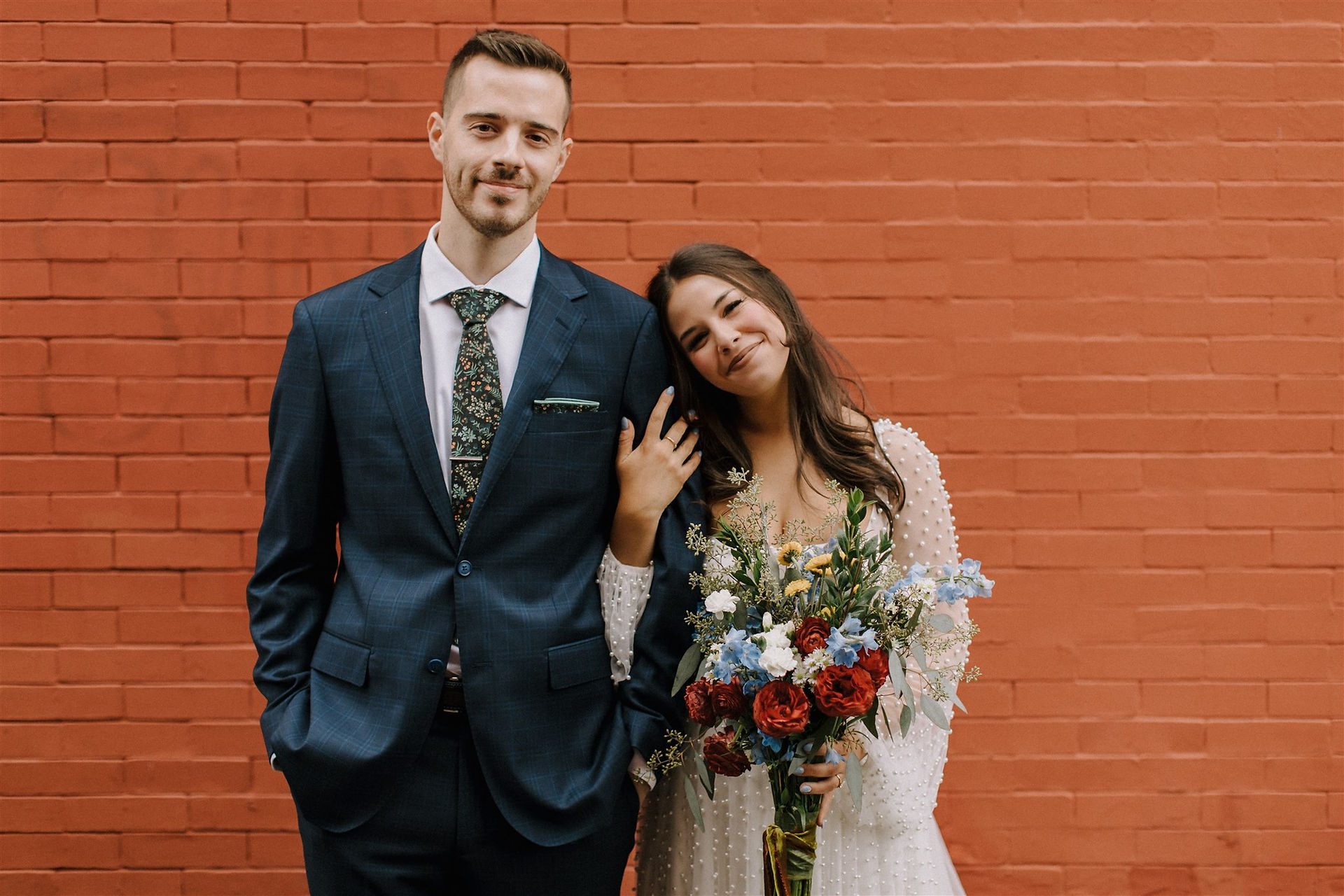 Bride and Groom portraits on wedding day with flowers and red brick wall downtown Peabody Massachusetts