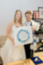 A married Jewish couple holding up their signed Ketubah