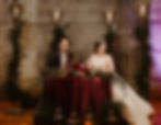 Married couple sitting at table surrounded by spooky alternative wedding decor
