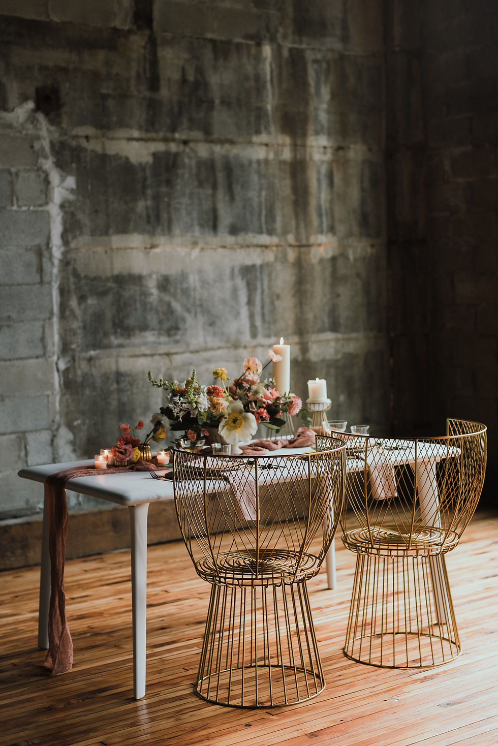 Simple metal chairs and floral centerpiece on a wooden table, sustainable wedding decrations