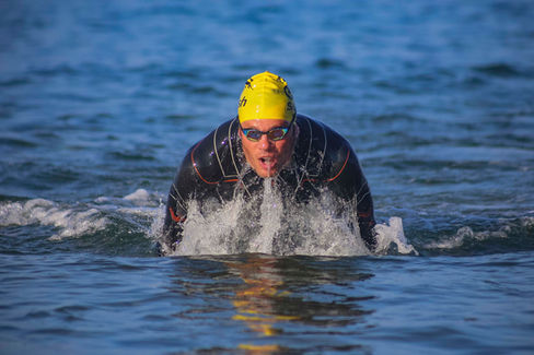 Primer plano de un triatleta saliendo del mar después de nadar.