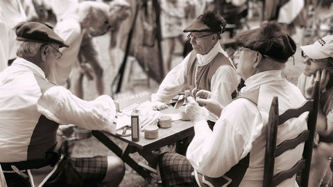 Three men in traditional attire seated at a table