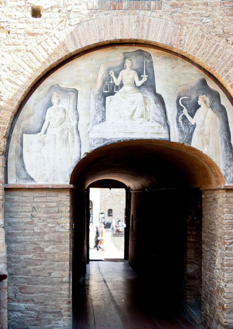 Arched brick entrance with classical relief sculpture and murals photographed by Jean Banzhoff