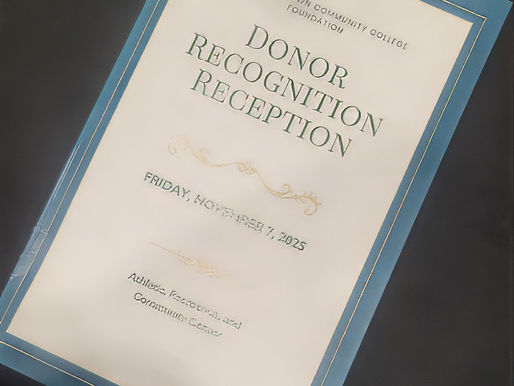 Designer offering business card at a scholarship reception, symbolizing imperfect but intentional networking.