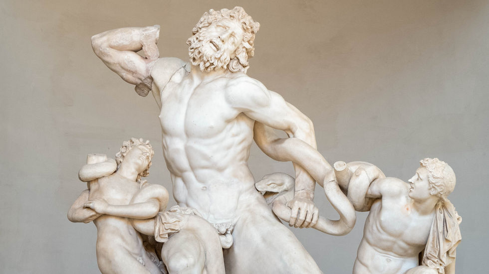 Marble sculpture of Laocoön and his two sons being attacked by sea serpents; all three figures are muscular and contorted in agony, with serpents wrapped around their limbs and bodies—depicting intense emotion and mythological struggle.