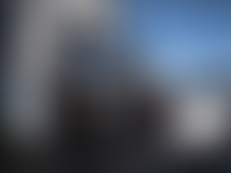 A spray painting robot poised over metal parts