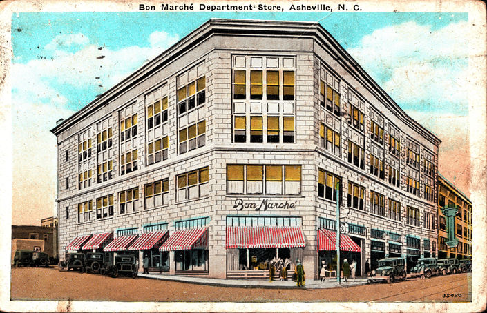 A vintage photograph of an Asheville department store with bright red awnings
