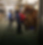 Volunteers, staff and riders with horse in barn