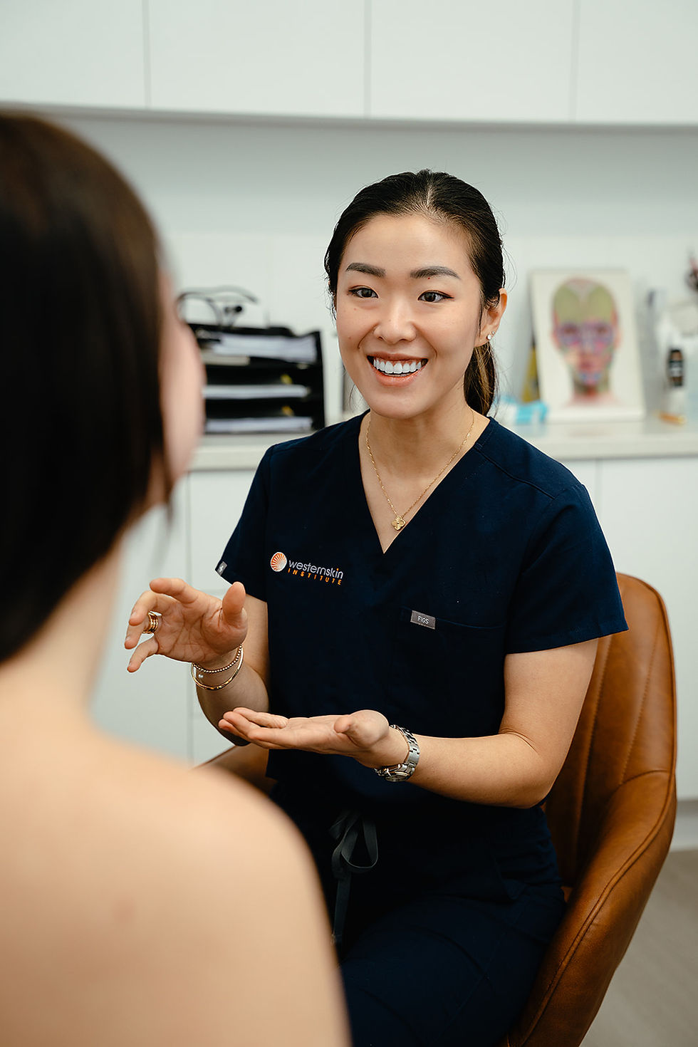 Medical professional in blue scrubs consulting a patient