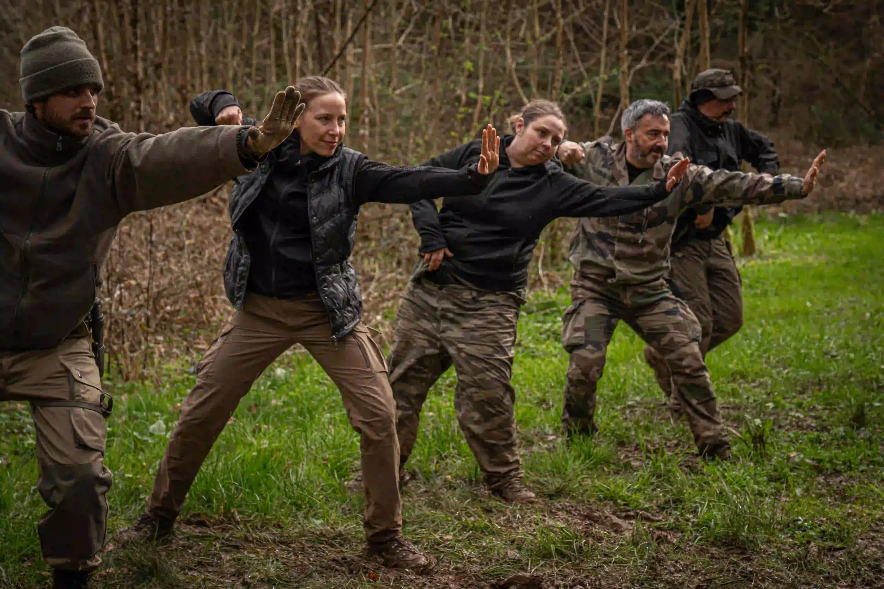 Participants practising a coordinated outdoor exercise in woodland