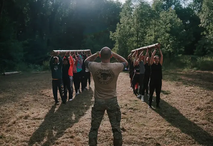 Delta Survival School team-building session with PwC employees, led by Instructor Delta, focusing on teamwork and survival skills in Luxembourg