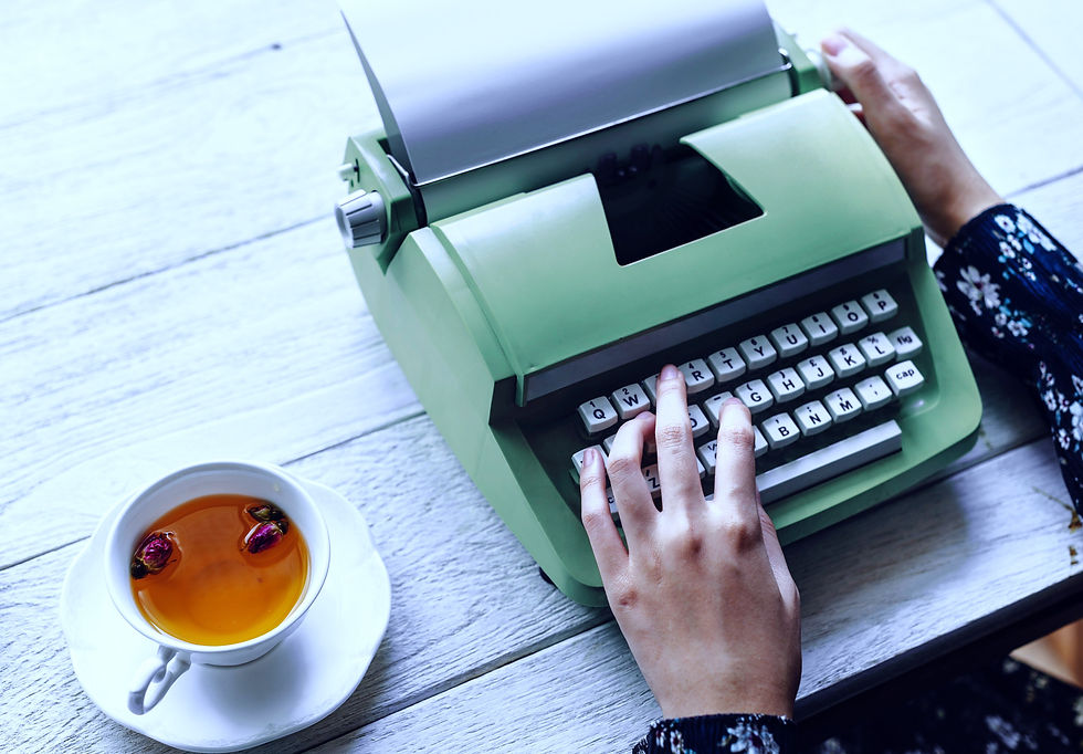 Hände tippen auf einer alten Schreibmaschine, Tee daneben