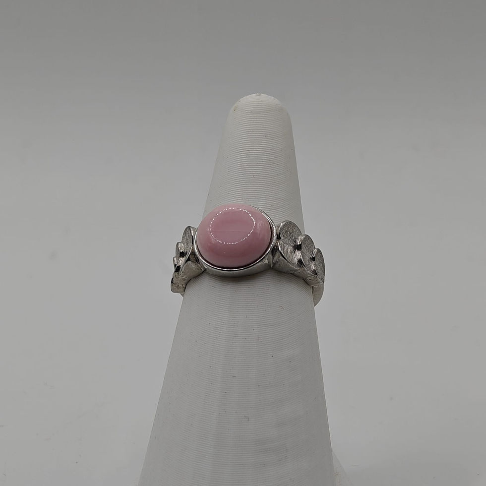 Bague réglable en argent rhodié avec cabochon rond en nacre rose des Antilles, ornée de cœurs. Vue de face