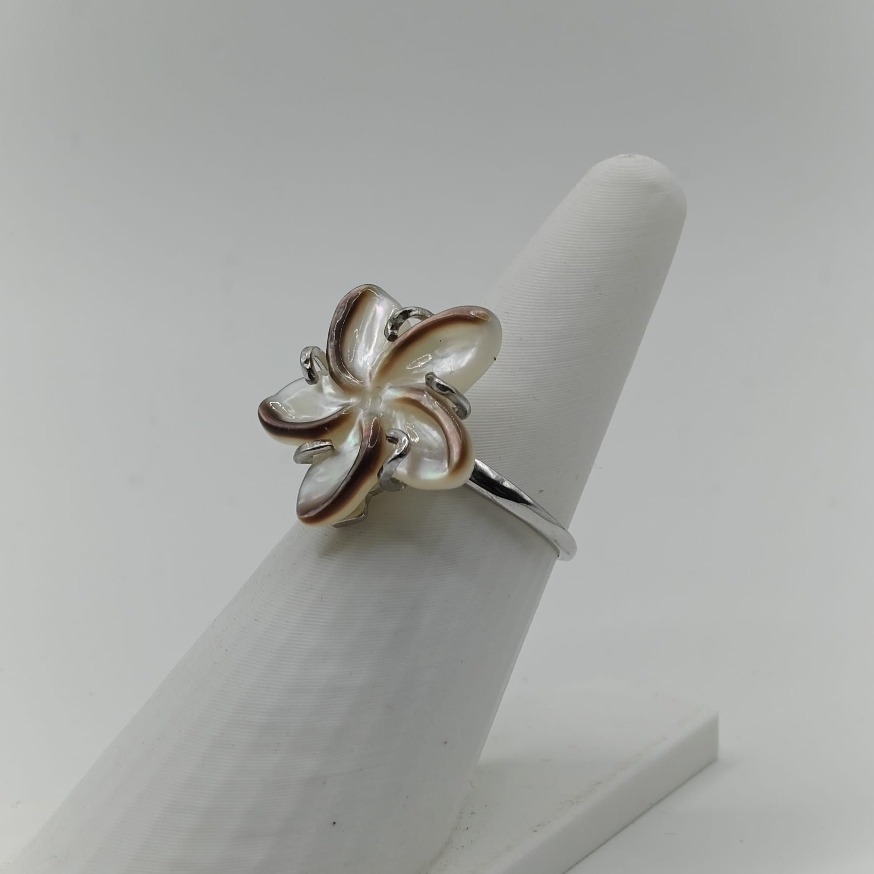 Bague réglable en argent rhodié avec fleur de frangipanier sculptée en nacre de Tahiti collection Manava. Vue de coté