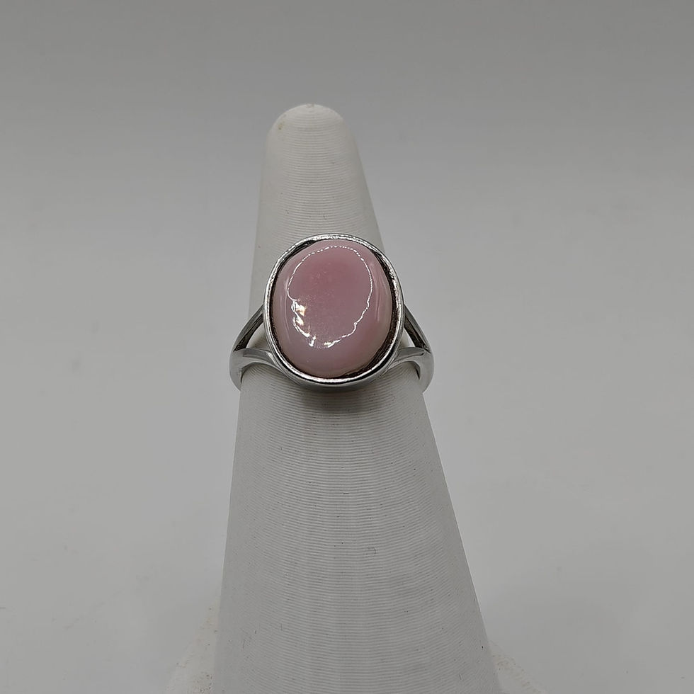Bague ovale réglable en argent rhodié avec cabochon en nacre rose des Antilles, d’un rose poudré lumineux. Vue de face