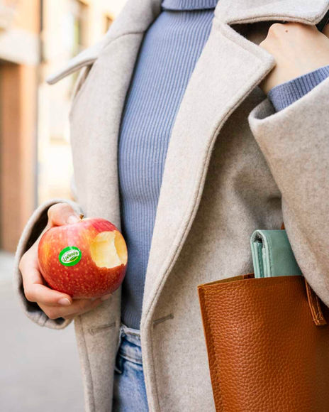 Fotografia de producte lifestyle, realitzada per Anna Viñas, d'una noia menjant una poma mentre va a la feina.