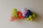 Colorful balloon arch with pink, red, green, purple, and blue balloons.