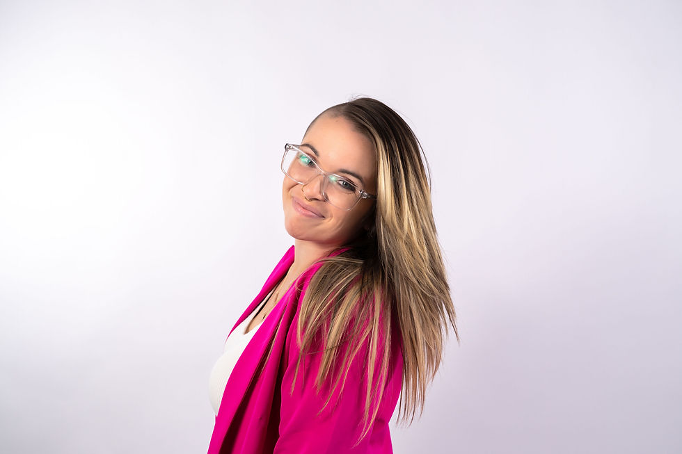 Jorden smiles in glasses and a pink blazer.