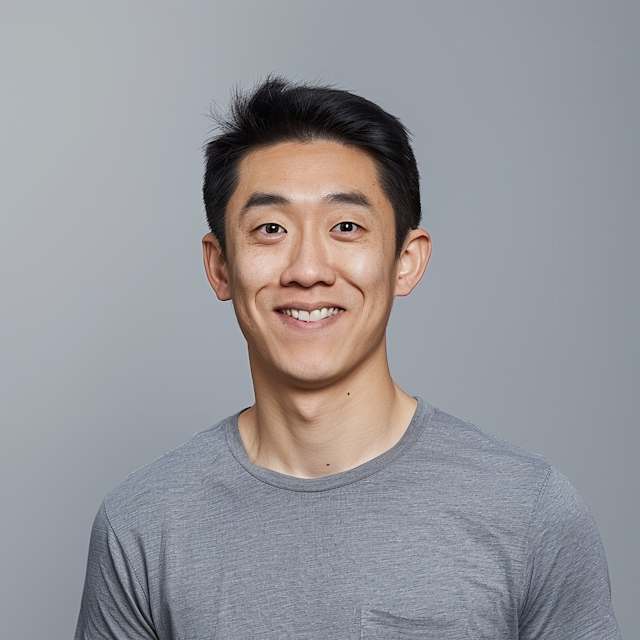 Young Man Smiling Against Gray Background.png