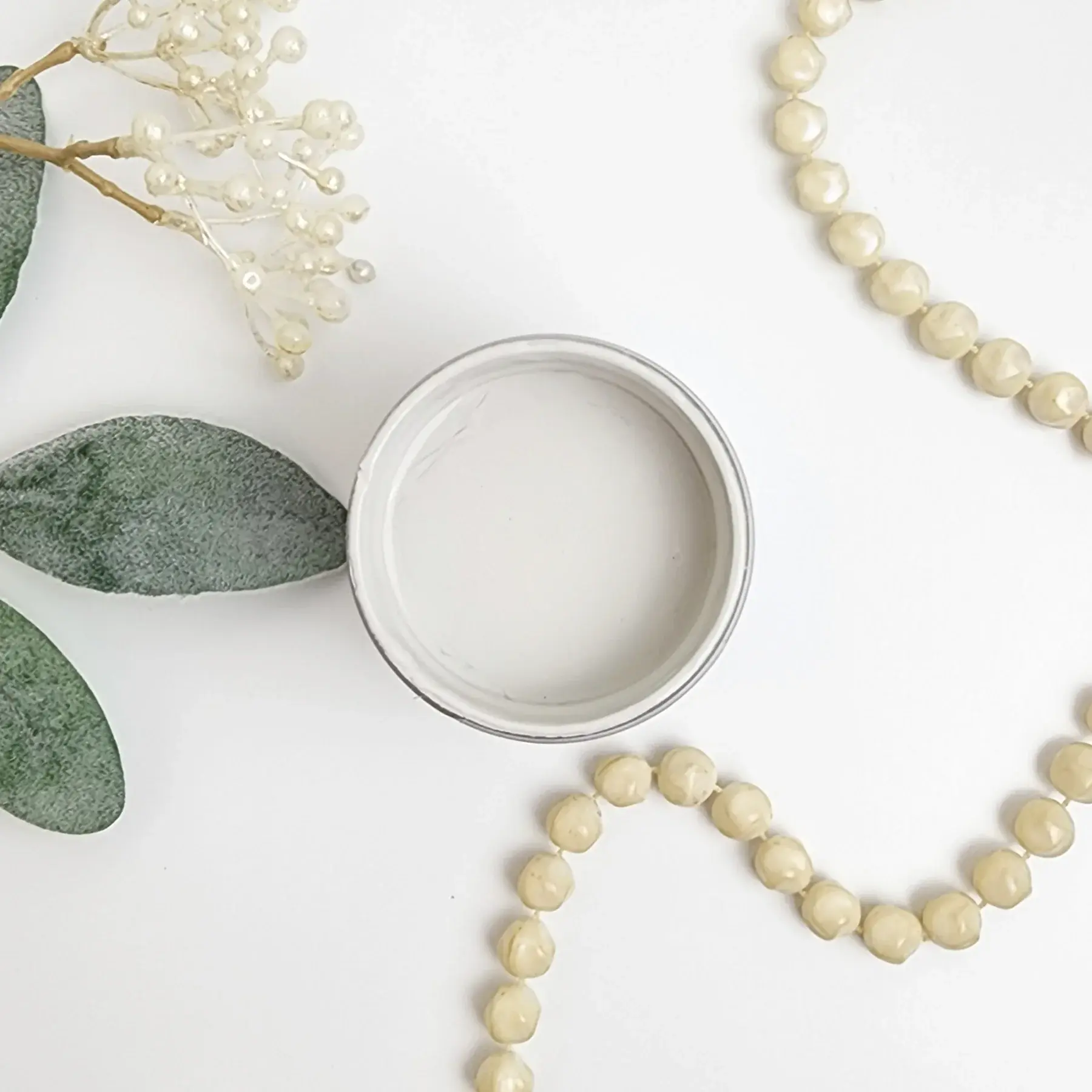 Mineral Paint Guatav in a circular container with pearls.