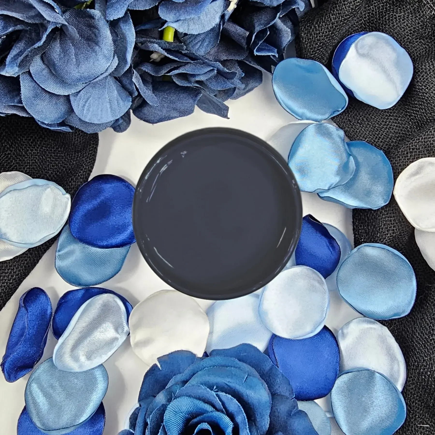 Mineral Paint Abyss swatch surrounded by blue flower petals