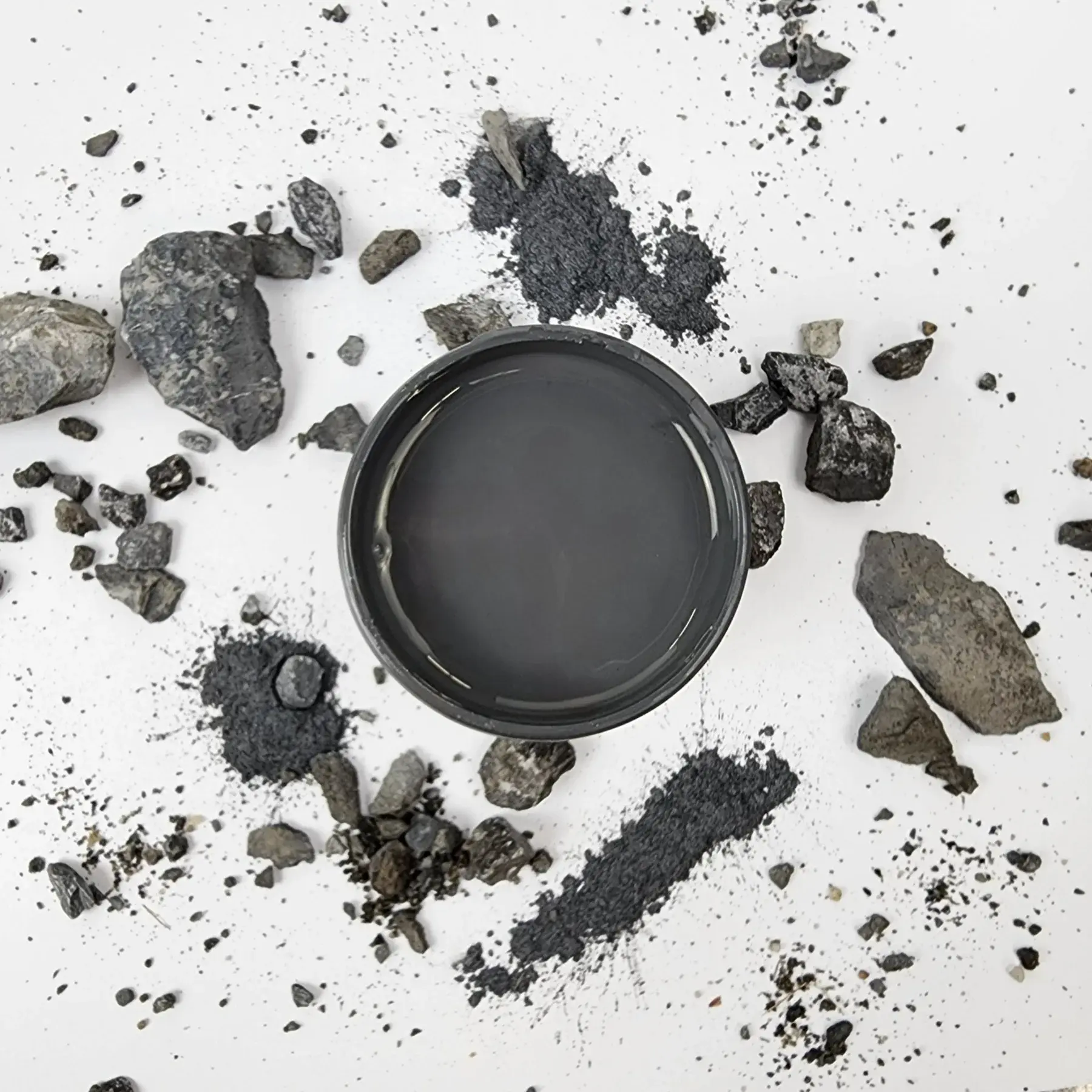 Mineral paint carbon in a bowl surrounded by raw charcoal