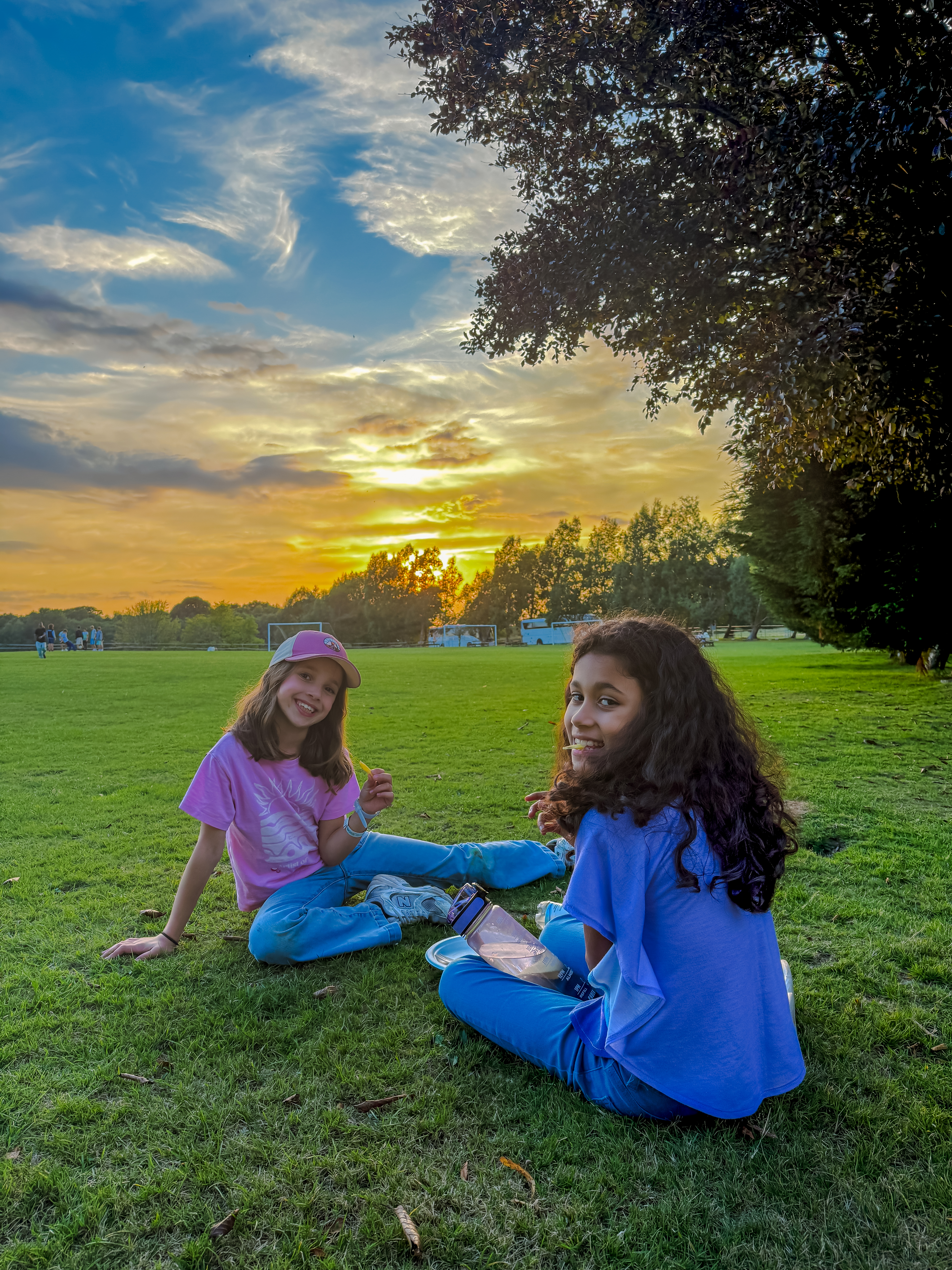 Students relaxing on the grass at sunset