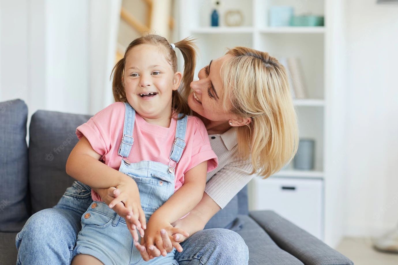 young-mother-embracing-her-disabled-child-while-they-sitting-sofa-room_249974-4406.webp