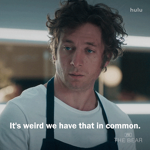 Man in a white shirt and apron, looking contemplative. Text: "It's weird we have that in common." Hulu FX The Bear logo in corner.