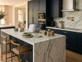 Modern dark blue kitchen with a beautiful, white Kitchen Marble Slab on the island.