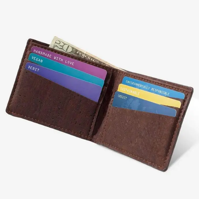 Angled view of an open minimalist vegan cork wallet revealing internal slot compartments filled with colorful credit cards