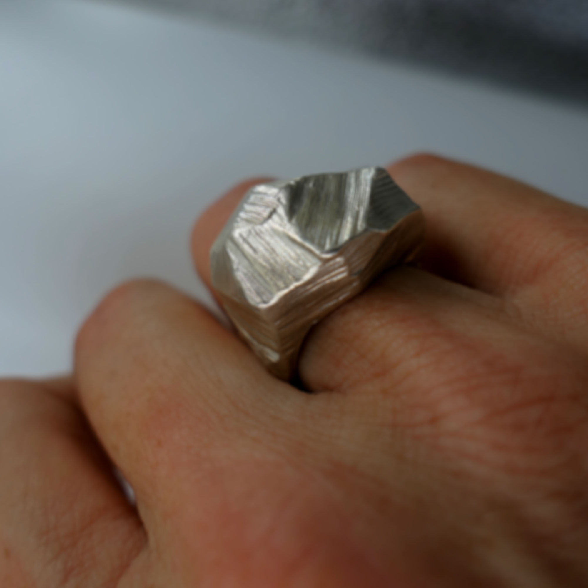 טבעת כסף 925 מעוצבת בעבודת יד עם מרקם גולמי פראי ואסימטרי על יד