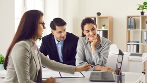 A real estate professional meeting with clients in a modern office, demonstrating professionalism, attentive communication and the consistent standards that help build a strong reputation over time