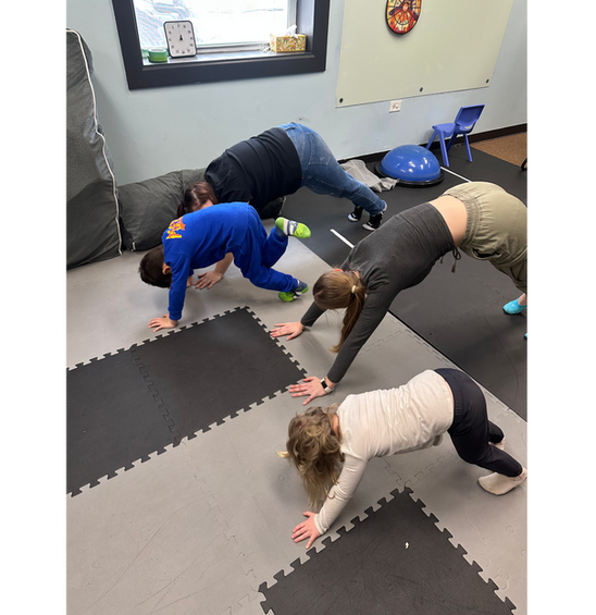 Children and adults are practicing yoga.