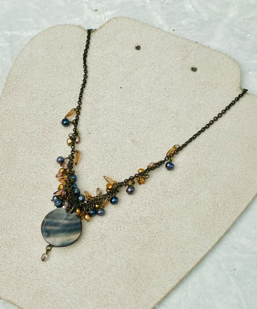 Elegant necklace with blue and gold beads, Compass Star Pendant, on display.