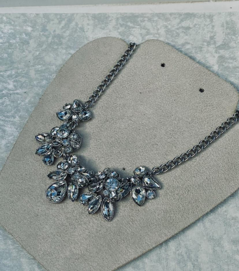 Close-up of a silver necklace, with silver droplets. Timeless Jewellery