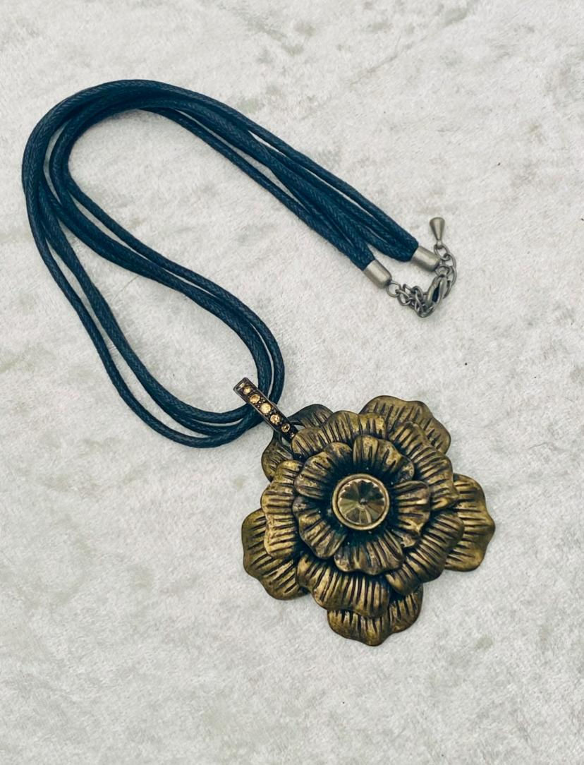 Golden flower pendant on black cord necklace. Timeless Jewellery. Elegant design.