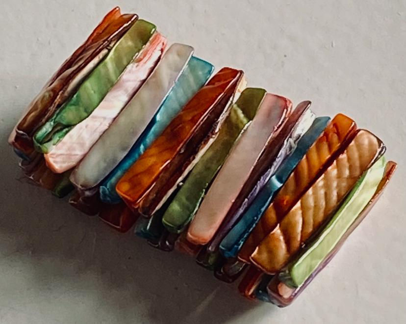 Colorful beaded bracelet close-up view on a white surface. Timeless Jewellery.